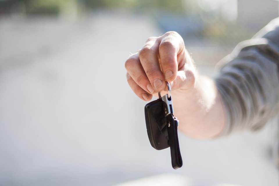 Una mano tiende las llaves de un coche