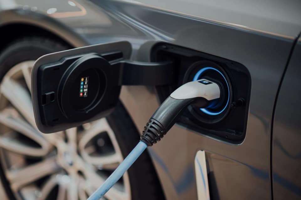 Cable de carga enchufado en la toma de un coche eléctrico