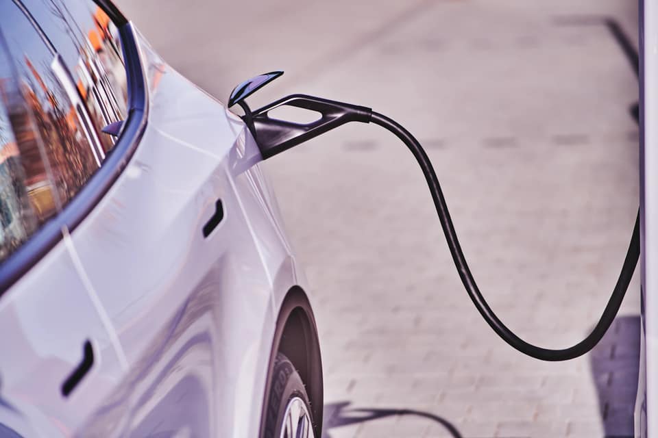 Coche eléctrico gris conectado a un punto de carga