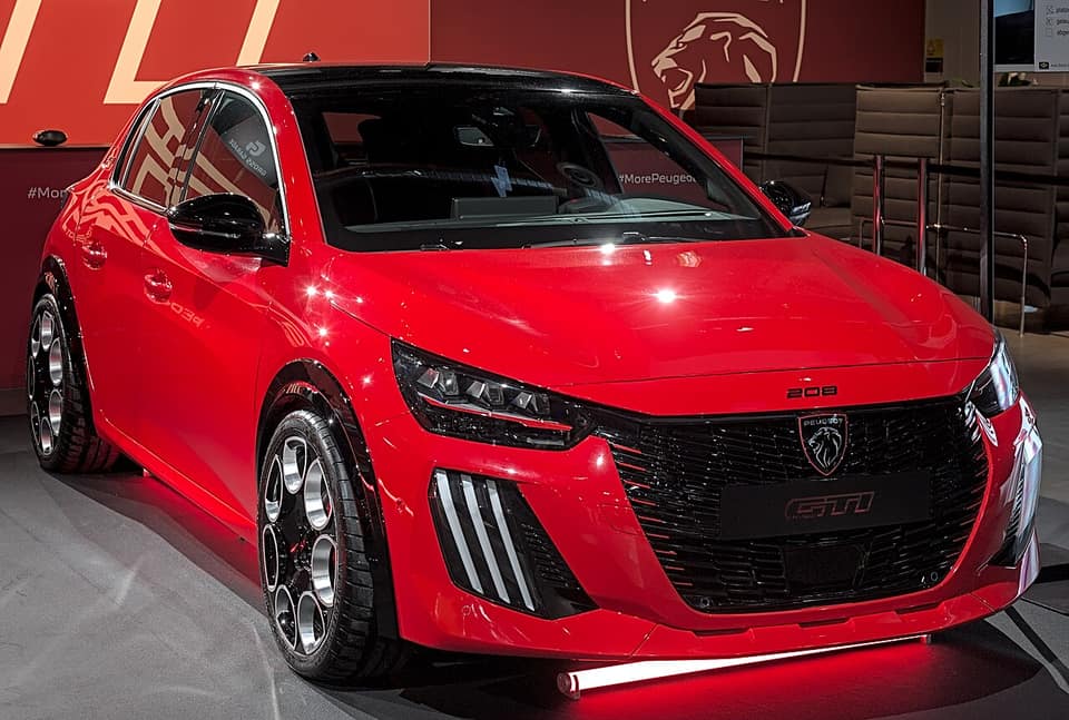 Peugeot E-208 GTi rojo visto de frente en el salón Auto Zürich 2025