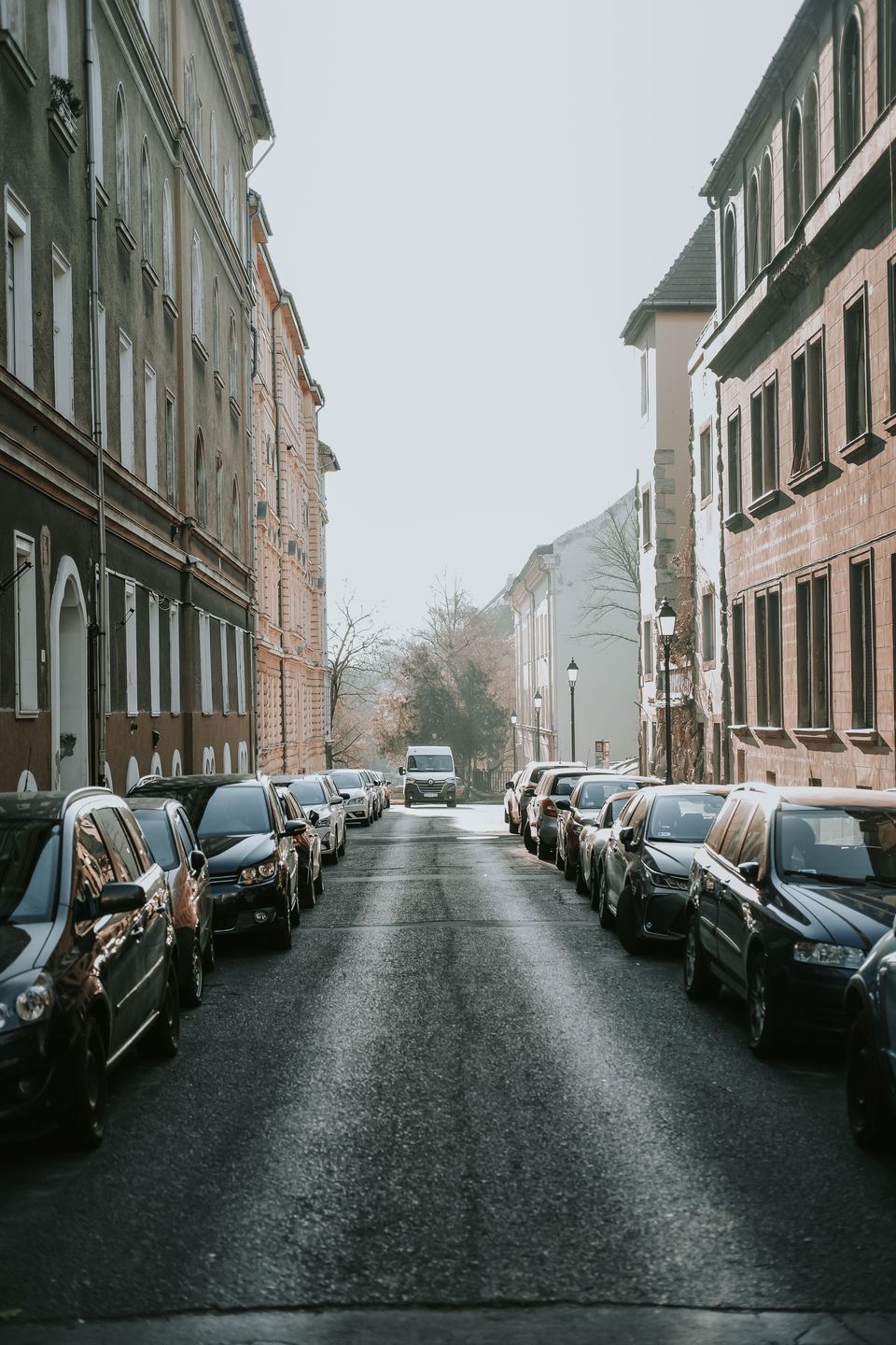 Calle de una ciudad europea con coches aparcados junto a la acera
