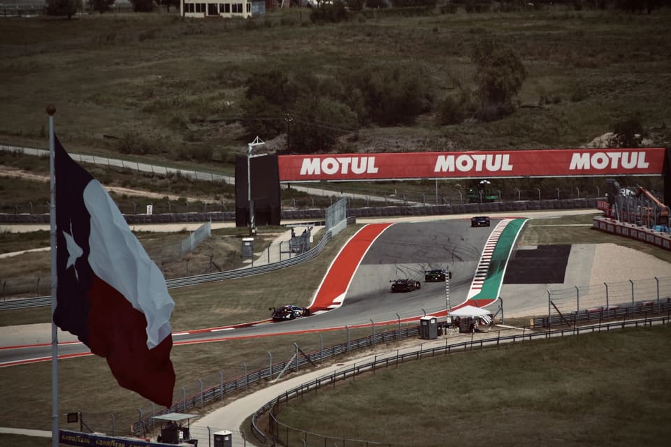 Monoplazas en el Circuito de las Américas de Austin, con la bandera de Texas